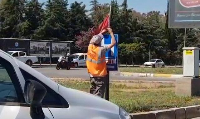 Yerde bulduğu Türk bayrağını temizleyip, tabelaya astı