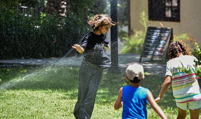 Antalya'da sıcaktan bunalanlar fıskiye ile serinledi, turistler gezerken şemsiye ve şapka kullandı