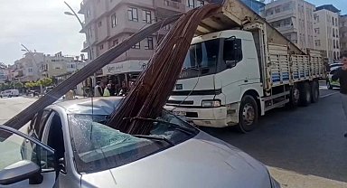 Kamyonun kasasından düşen inşaat demirleri, otomobilin tavanını deldi
